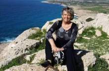 Greta sitter på en klippa vid havet, Cypern